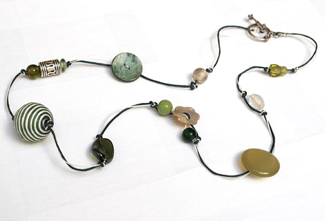 Caroline bead and button necklace - Stylish and eye-catching long necklace. Mixture of green and white beads and buttons of varying sizes. Strung and knotted with double thread and fastened with an ornate toggle bar and ring.