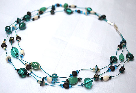 Claire green three-tiered necklace - Beautiful blue green mixed glass and foil beads interspersed with small chocolate brown, heart-shaped beads. Strung and knotted onto dark blue thread.