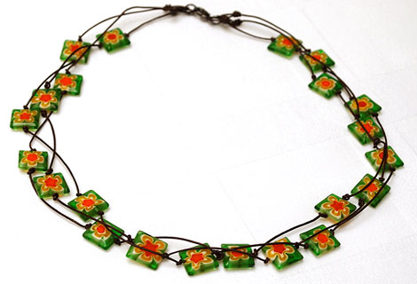 Spangle green 3-tiered necklace - Eye-catching bright green square glass beads with orange flower pattern. Strung in three rows on to knotted dark brown cord. Lobster clasp.